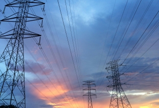 Elektrimastid ja elektriliinid päikese taustal. 